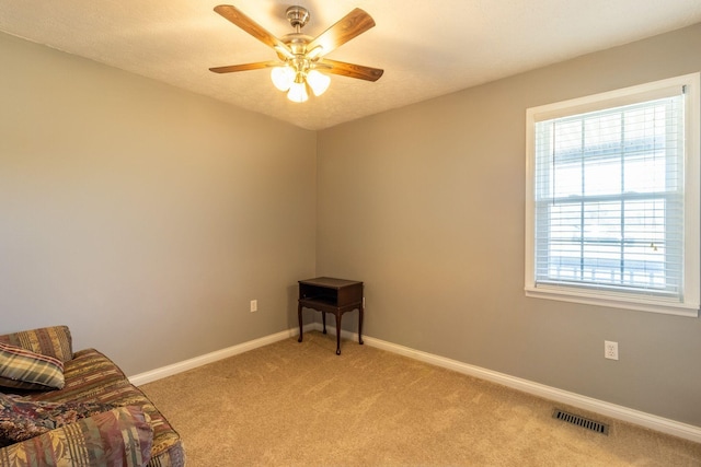 unfurnished room with visible vents, a ceiling fan, baseboards, and light carpet