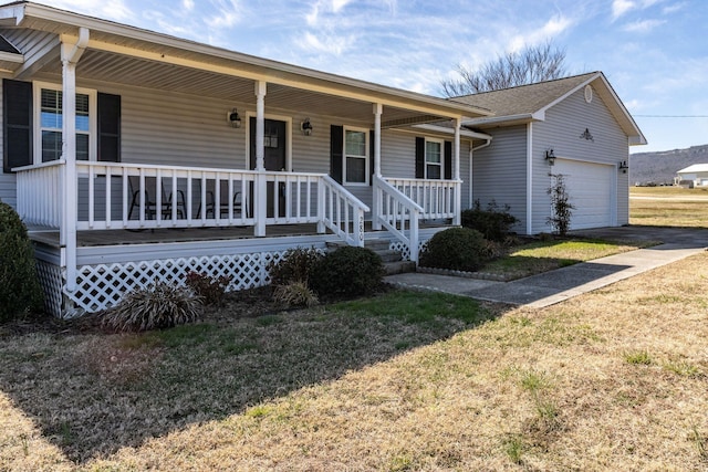 ranch-style house with an attached garage, driveway, a porch, and a front lawn