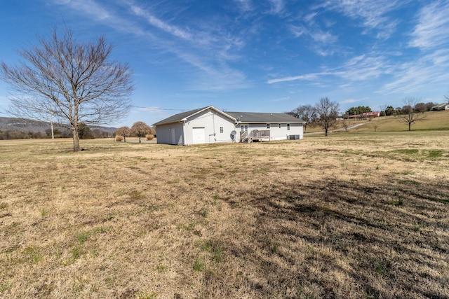 exterior space with a wooden deck, a rural view, and a front yard