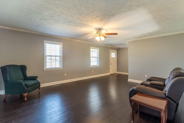 living area with a ceiling fan, baseboards, a textured ceiling, and crown molding