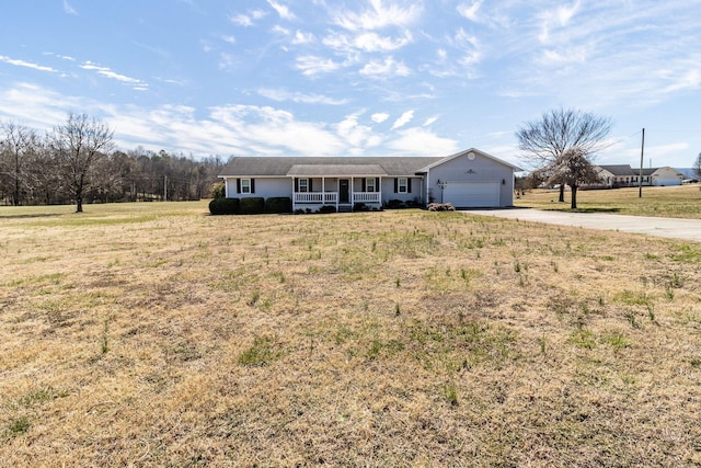 single story home featuring concrete driveway, a porch, a front yard, and a garage