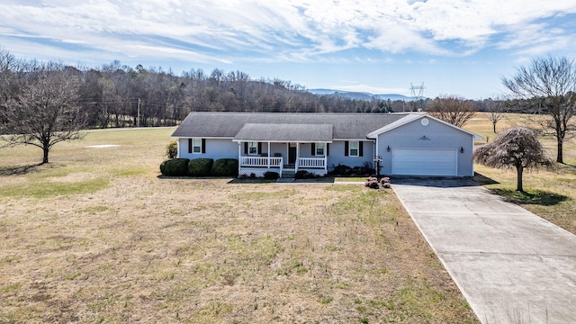 ranch-style home featuring a porch, an attached garage, driveway, and a front lawn