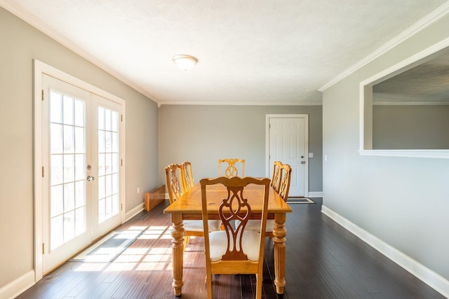 dining area featuring dark wood-type flooring, baseboards, ornamental molding, and french doors