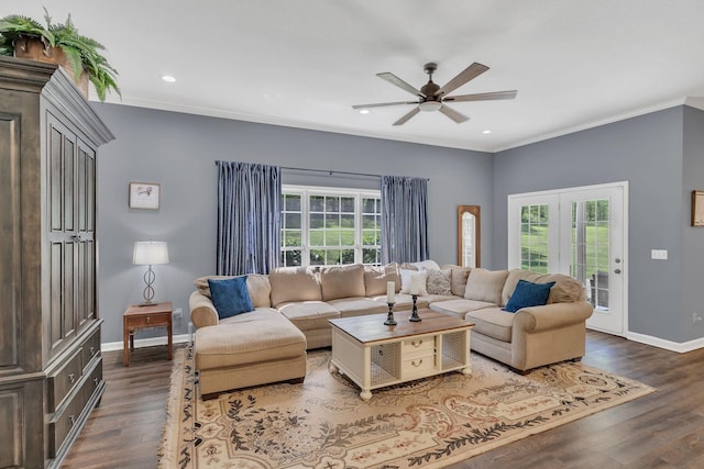 living area with baseboards, plenty of natural light, ornamental molding, and a ceiling fan