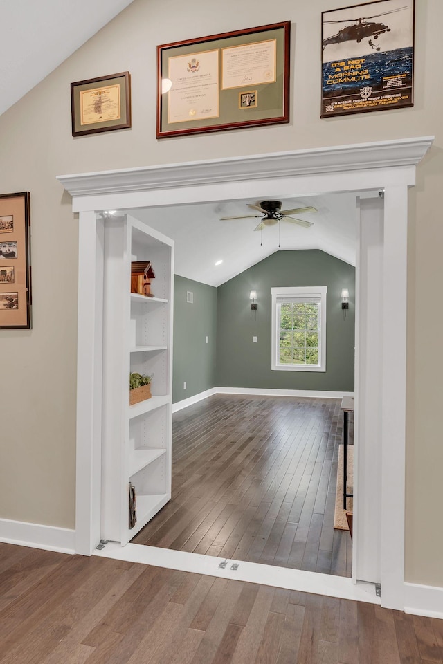 interior space featuring a ceiling fan, hardwood / wood-style flooring, baseboards, and lofted ceiling