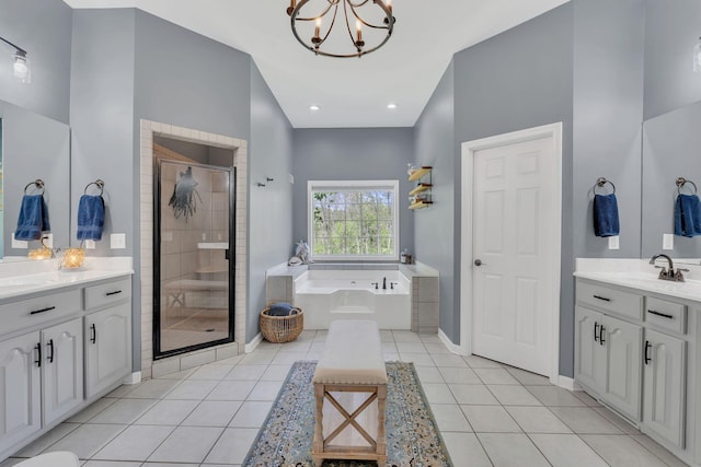 full bathroom with a chandelier, two vanities, a bath, and a stall shower