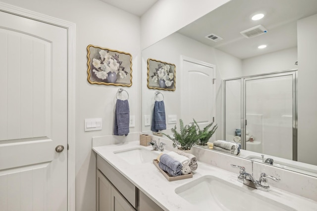 bathroom with visible vents, a sink, and a shower stall