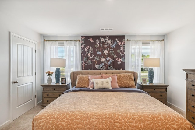 carpeted bedroom with wallpapered walls, visible vents, baseboards, and multiple windows