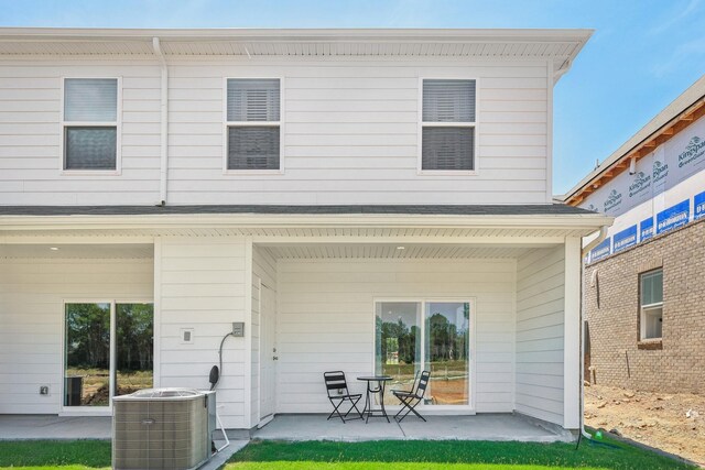 rear view of property featuring a patio area, a shingled roof, and central air condition unit
