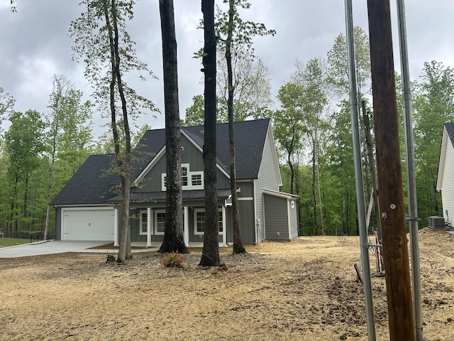 view of front facade with a garage, a shingled roof, central AC unit, board and batten siding, and concrete driveway