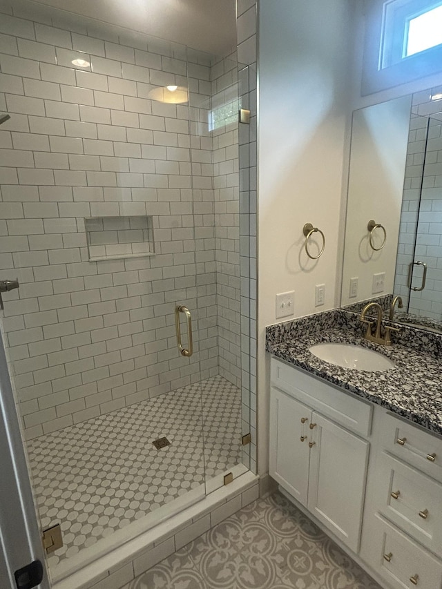 full bath with vanity, a stall shower, and tile patterned floors