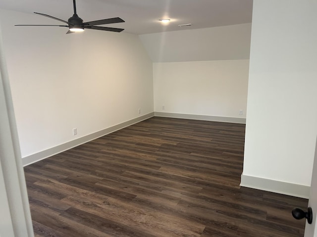 empty room with dark wood-style flooring, ceiling fan, baseboards, and lofted ceiling