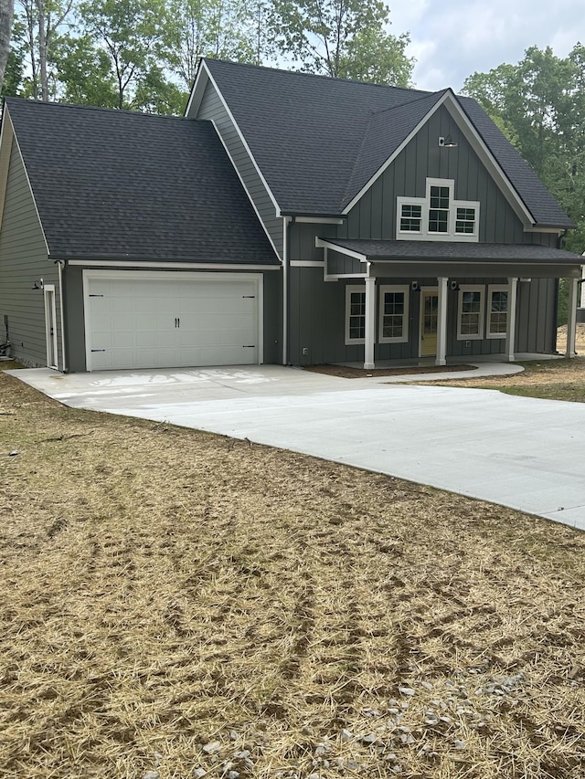 view of front facade featuring board and batten siding, covered porch, a garage, concrete driveway, and a shingled roof