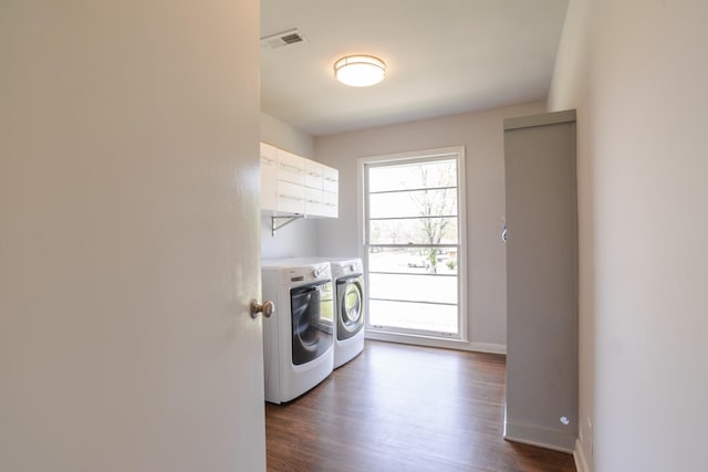 laundry area featuring laundry area, baseboards, visible vents, washer and dryer, and dark wood-type flooring