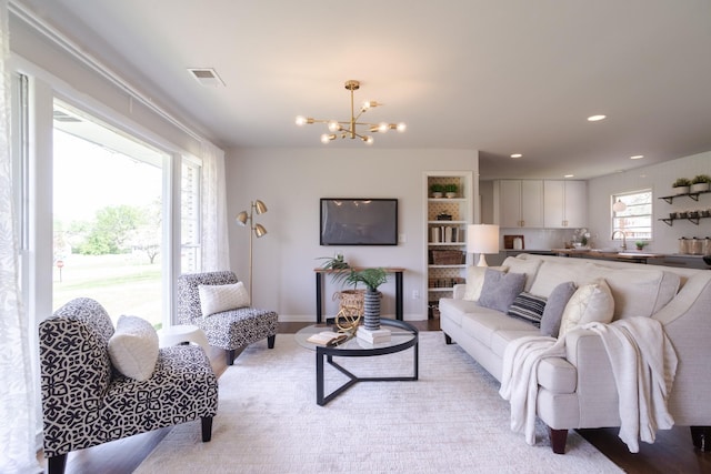 living room with a notable chandelier, visible vents, and recessed lighting