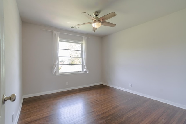 unfurnished room featuring baseboards, visible vents, ceiling fan, and dark wood finished floors