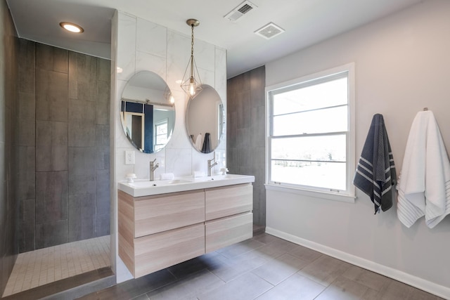 full bathroom with tile patterned floors, a sink, double vanity, visible vents, and a walk in shower