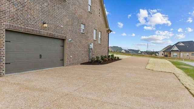 1111 Joe Martin Ln, Lebanon, TN 37087 - view of side of property with a garage, a residential view, brick siding, and concrete driveway