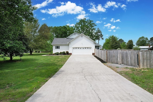 ranch-style house featuring a front lawn, driveway, an attached garage, fence, and roof with shingles