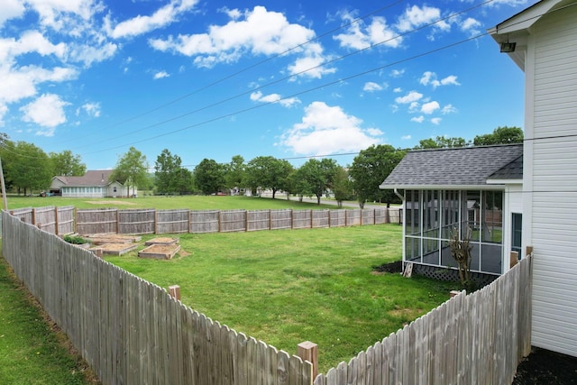 view of yard featuring a fenced backyard, a sunroom, and a vegetable garden