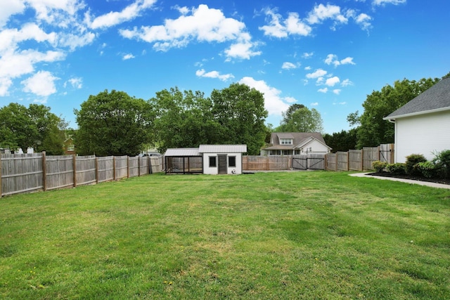 view of yard featuring a fenced backyard, an outbuilding, and a shed