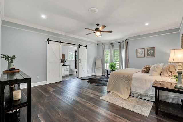 bedroom featuring wood finished floors, baseboards, and a barn door