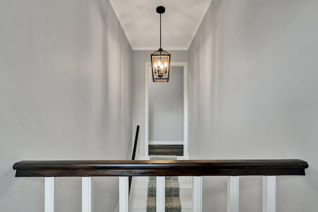 stairs with crown molding and a notable chandelier