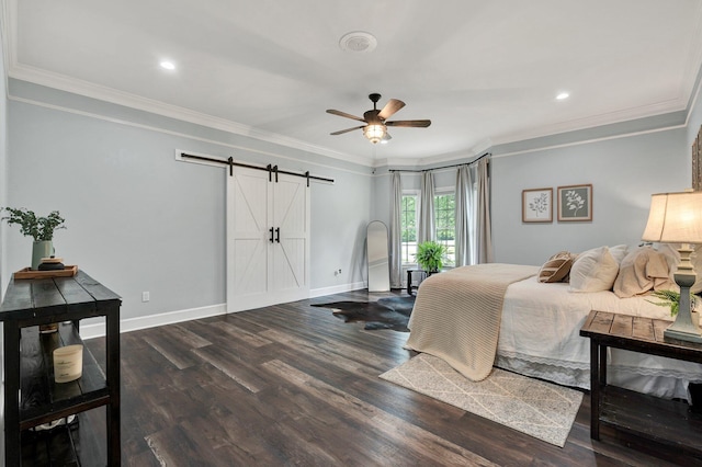 bedroom featuring crown molding, baseboards, wood finished floors, and a barn door