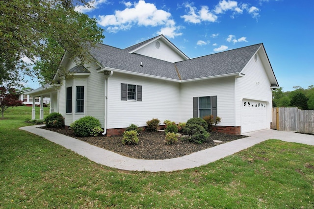 view of property exterior with fence, concrete driveway, a lawn, roof with shingles, and a garage