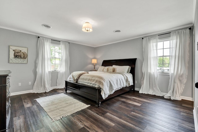 bedroom with visible vents, crown molding, baseboards, and dark wood-style flooring