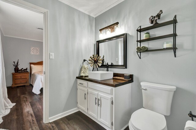 ensuite bathroom featuring wood finished floors, connected bathroom, vanity, toilet, and ornamental molding