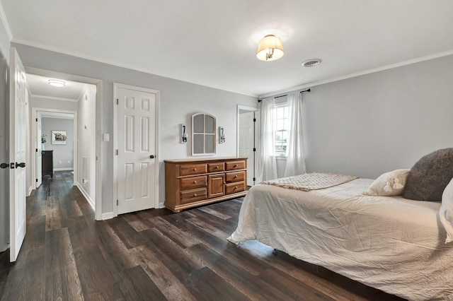 bedroom featuring baseboards, visible vents, dark wood-style floors, and ornamental molding
