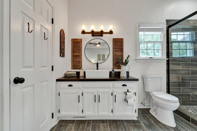 bathroom featuring vanity, toilet, a stall shower, and baseboards