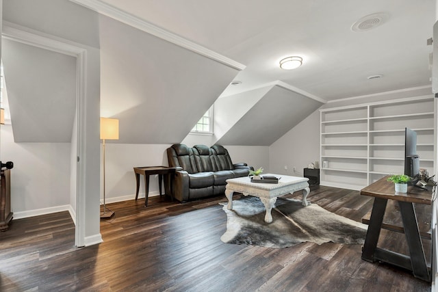 interior space with lofted ceiling, dark wood-type flooring, crown molding, baseboards, and built in shelves