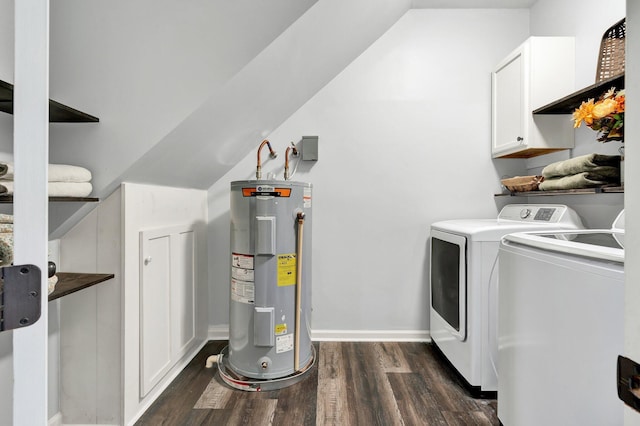 laundry area with dark wood finished floors, electric water heater, baseboards, separate washer and dryer, and cabinet space