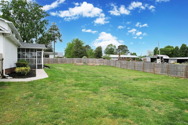 view of yard with a sunroom and a fenced backyard