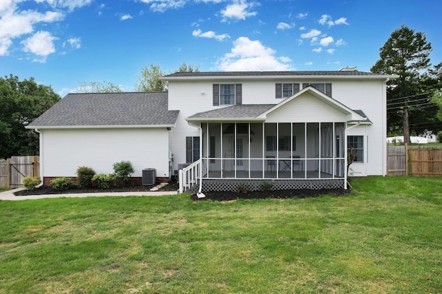 rear view of house featuring fence, a sunroom, a yard, and central AC