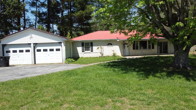 ranch-style home featuring metal roof, a front lawn, driveway, brick siding, and a garage