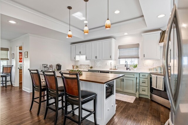 8803 Horton Hwy, College Grove, TN 37046 - kitchen featuring stainless steel appliances, dark wood-style floors, a kitchen bar, and butcher block countertops
