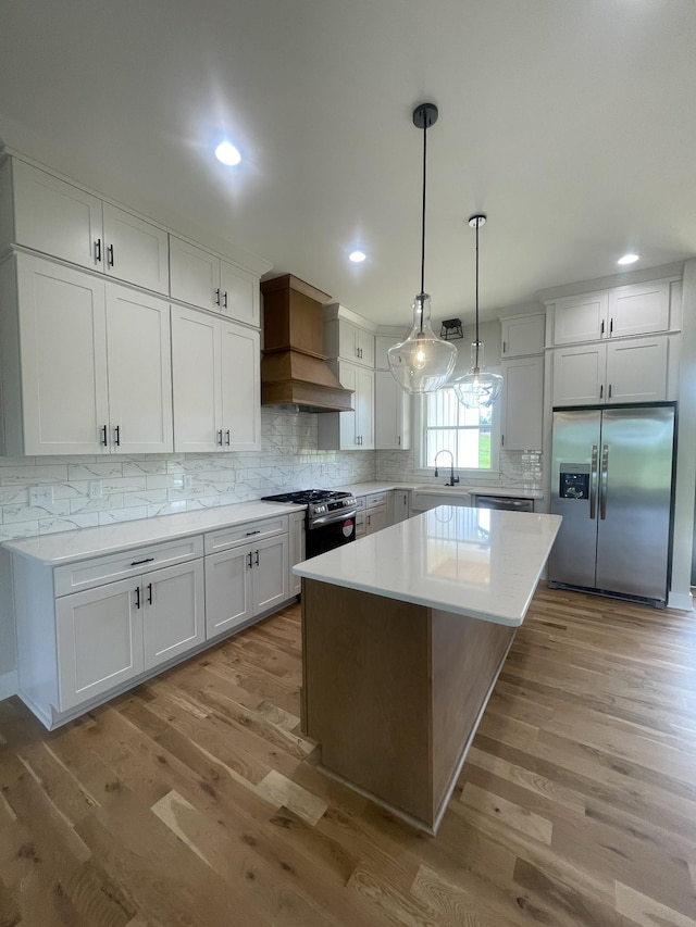 1167 Rock Church Rd, Dickson, TN 37055 - kitchen featuring a center island, light wood-type flooring, stainless steel appliances, and decorative backsplash