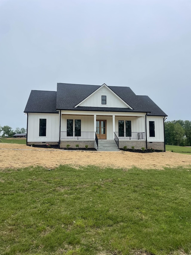 1167 Rock Church Rd, Dickson, TN 37055 - view of front of house featuring covered porch, a front yard, a shingled roof, and board and batten siding