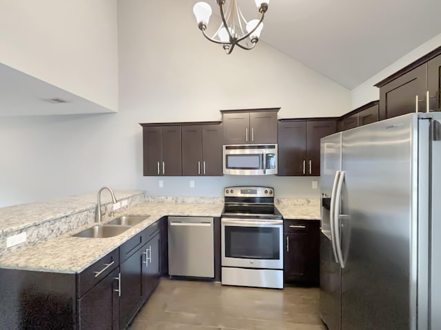 kitchen with dark brown cabinetry, stainless steel appliances, a sink, and high vaulted ceiling
