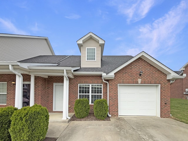 townhome / multi-family property with brick siding, a shingled roof, a garage, and concrete driveway