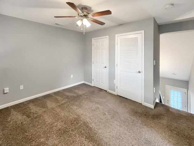 unfurnished bedroom with dark colored carpet, visible vents, a ceiling fan, and baseboards
