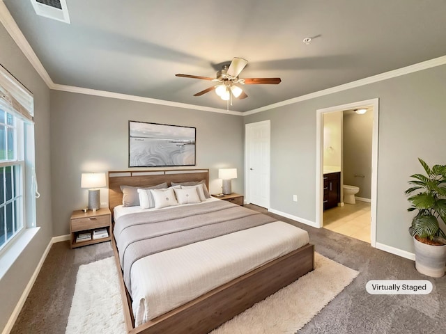 carpeted bedroom featuring visible vents, a ceiling fan, ensuite bath, crown molding, and baseboards