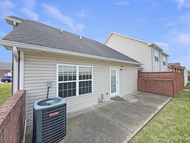 back of house featuring central AC, a patio area, and a shingled roof