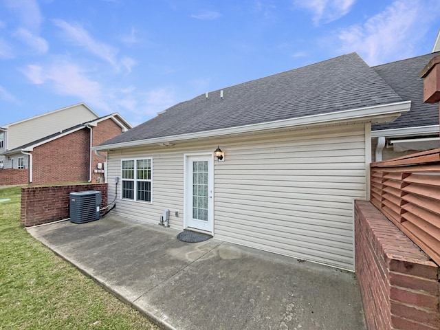 rear view of house with a shingled roof, central AC, and a patio