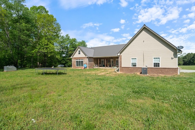 703 Gaither Hinson Rd, Waynesboro, TN 38485 - back of property with a trampoline, a yard, central AC, and brick siding