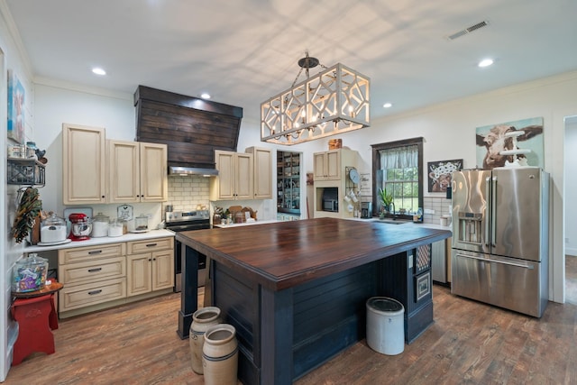 703 Gaither Hinson Rd, Waynesboro, TN 38485 - kitchen with cream cabinets, appliances with stainless steel finishes, wooden counters, backsplash, and under cabinet range hood