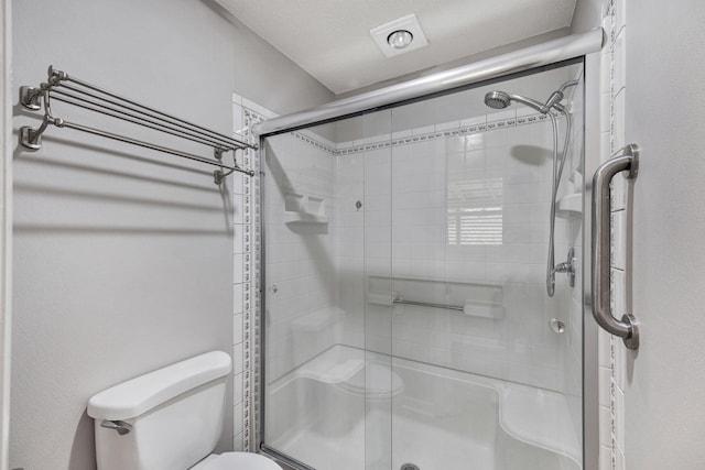 full bathroom with toilet and a stall shower